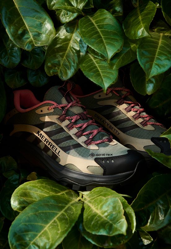 Merrell x Sweaty Betty Moab Speed 2 GORE-TEX shoes among green leaves.